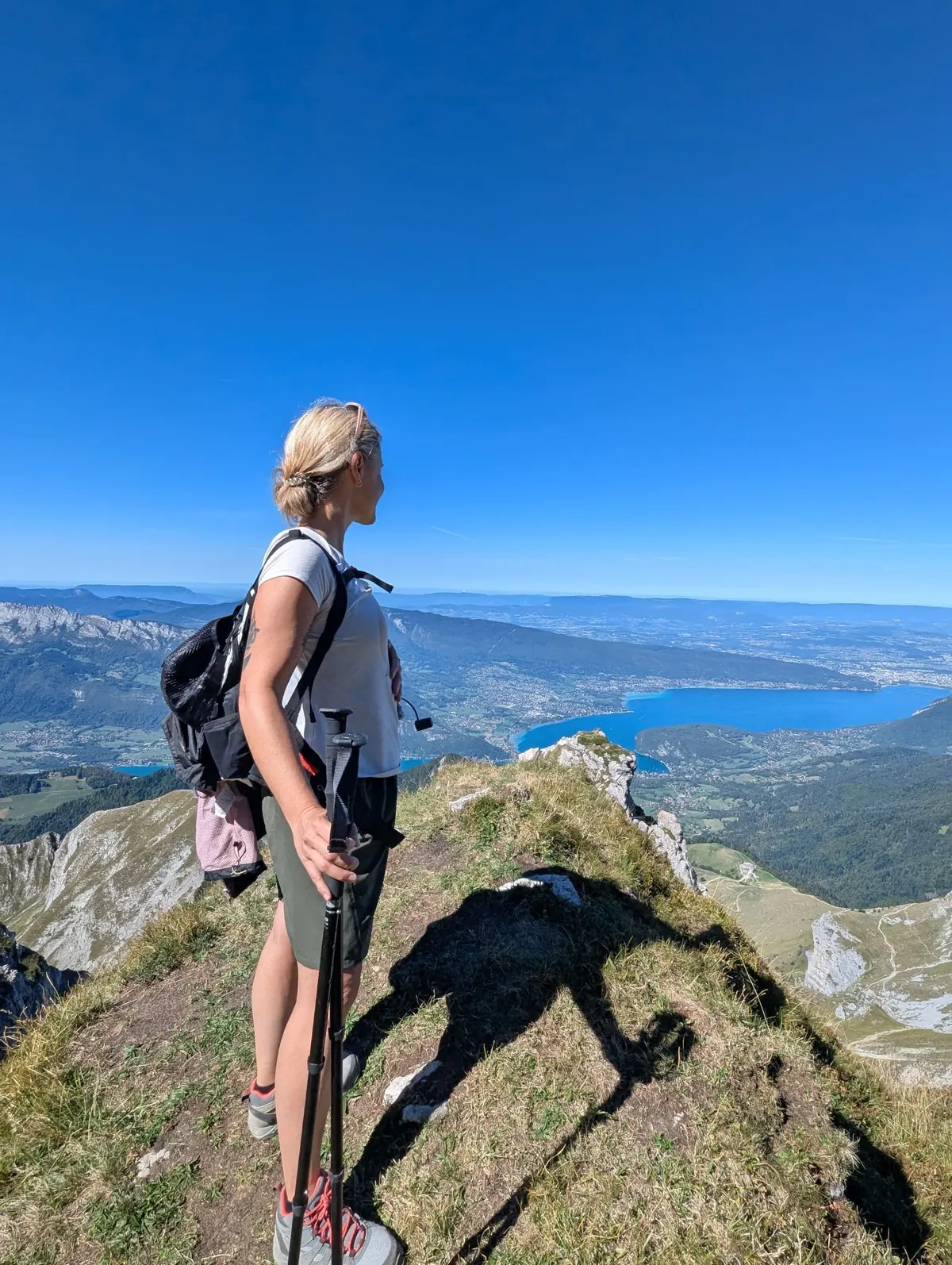 Floriane en randonnée sur une crête, face au lac d'Annecy et aux montagnes de Haute-Savoie